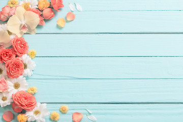 beautiful flowers on blue painted wooden background