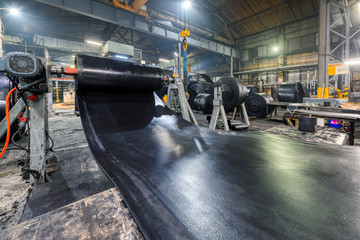 Interior of a factory for manufacturing rubber conveyor belts. - obrazy, fototapety, plakaty