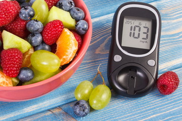 Fresh fruit salad and glucose meter, diabetes, healthy lifestyle and nutrition concept