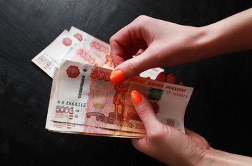 women's hands consider money large bills