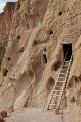 Ladder leading up to ancient cliff dwelling entrance at Bandelier National Monument in New Mexico desert