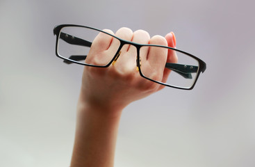 The female hand that holds the glasses