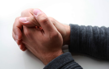 male hands folded on the table