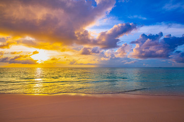 Fototapeta na wymiar Beach sunset, sun rays, beams over colorful sky. Tranquil sea waves and seascape. Tropical, Mediterranean sea sunset with horizon 