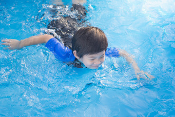 Boy swimming and playing in a pool