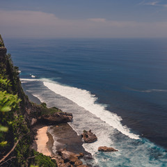 The beautiful nature of Indonesia and the island of Bali. Slopes and cliffs overlooking the waves of the blue ocean. Tropical and exotic view of travel to Asia