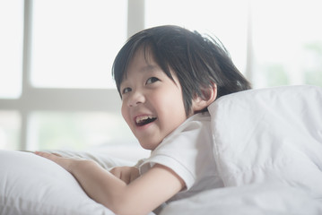 Cute asian child lying on a bed