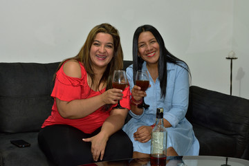 Two mature latin women making a toast