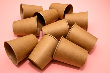 Craft paper cups for coffee or any drinks on a pink paper background. Concept of ziro waste, no plastic