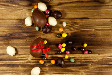 Easter composition with chocolate eggs on wooden background