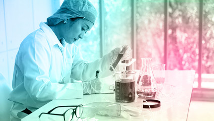 Asian Scientist Pipetting at a Biomedical Laboratory.Focused young life science professional...
