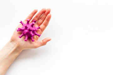 Corona virus Covid-19 - diagnostics concept with strain virus model and hands - on white background top-down copy space