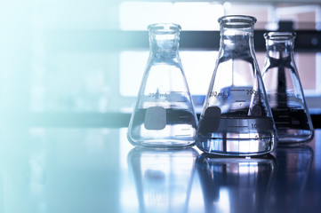 three glass flask in blue chemistry science laboratory background