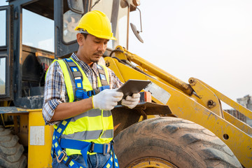 Engineer builder using tablet with Loader Truck at construction site,Construction concept. © visoot