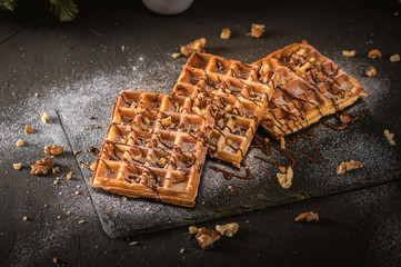 Belgian waffles topped with whipped cream, dark and white chocolate