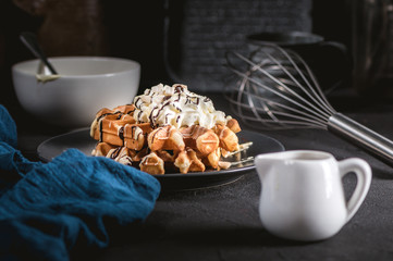 Belgian waffles topped with whipped cream, dark and white chocolate