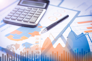 Business papers, pen, calculator with financial analysis graphs. Close-up of document with map and...