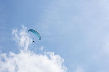 blauer paragleiter am himmel im sommer