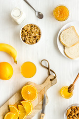 Granola for healthy breakfast. Still life composition with fruits and toast on white background top-down