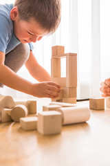 Fototapeta na wymiar Young dad play with building bricks with small son