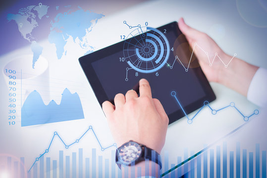 Businessman working on tablet with financial analysis graphs. Close-up of man changing online data. Unrecognizable employee sitting at table with mug and using portable computer. Technology concept