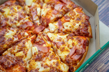 ham and pineapple on pizza in box