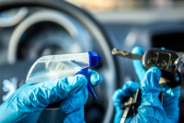 Coronavirus Epidemic Outbreak. Close-up of hand in protective glove disinfecting car key. 