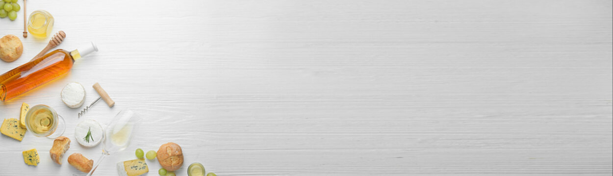 Delicious wine with snacks on white wooden background with space for text