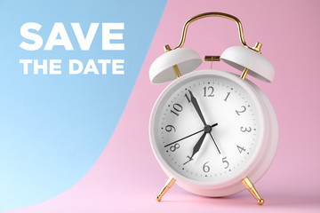Alarm clock and text SAVE THE DATE on color background
