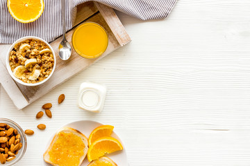 Homemade granola for morning meal. White desk with taost and fruits top-down frame copy space