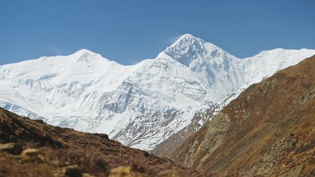 Huge snow stunning summit of Annapurna massif dominate over clear blue sky