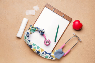 Stethoscope with cover, heart, clipboard and supplies on color background
