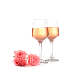 Glasses of wine with rose flowers on white background
