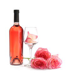Glass and bottle of wine with rose flowers on white background