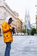 photographer tourist taking picture of city street with votive church on background