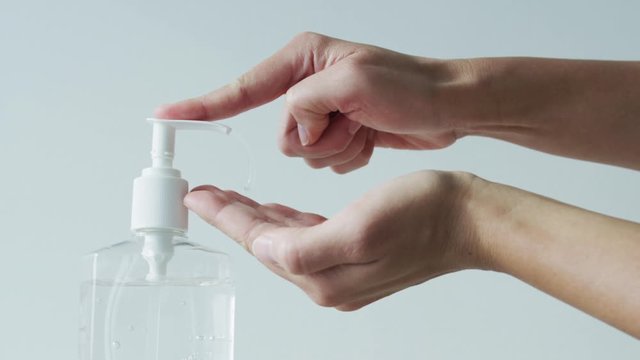 Hand sanitizer alcohol gel rub clean hands hygiene prevention of covid-19 coronavirus virus outbreak. Woman using bottle of antibacterial sanitiser gel. Slow motion on RED cinema camera.