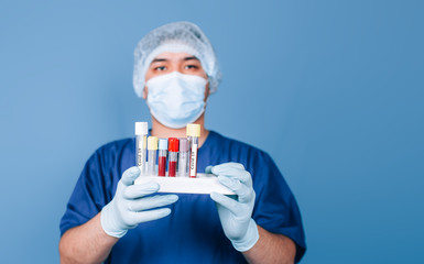 male doctor holding a tray with test tubes with blood tests for coronavirus SARS-CoV-2