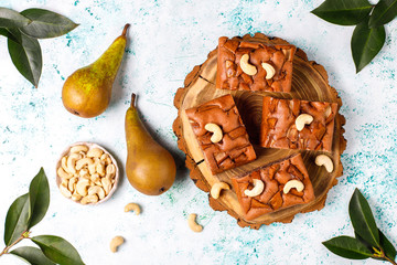 Homemade rustic chocolate cake with pear and cashew nuts,top view