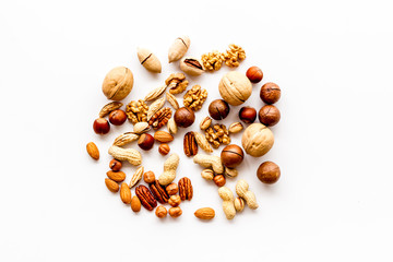 Nuts background - with almond, macadamia, walnut, hazelnut - on white table top-down