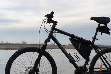 iew of the lake and sky with sunset from behind a black sports mountain bike