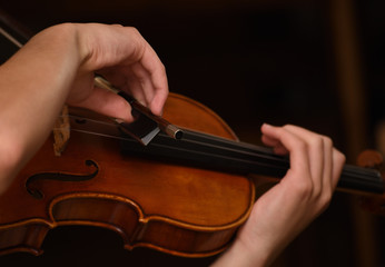 close up hands playing violin