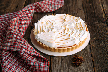 Meringue Cake on the wooden table with napkin, side view, horizontal