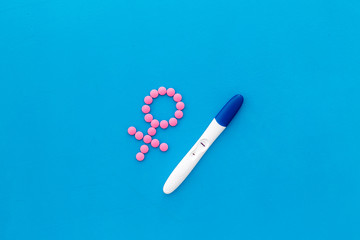 Pregnancy test with two strips and Venus sign - baby girl expectation - on blue background top-down