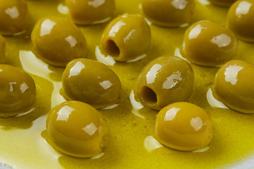 pitted green olives in olive oil. closeup