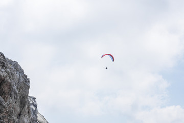 paragleiter bei einer felswand im gebirge