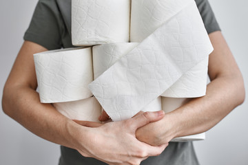 Woman holds many rolls of the toilet paper. Coronavirus covid-19 panic concept, stocking up toilet paper for home quarantine