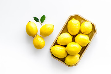 Ripe lemons in tray on white backgroud top-down