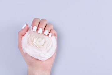 woman hands with manicure and wedding ring among white lace and little flowers