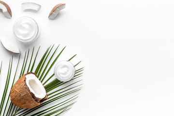 Skin care cream with coconut oil on white background top-down frame copy space