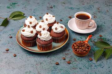 Coffee cupcakes decorated with whipped cream and coffee beans.